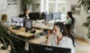 Employees sit at their workstations and talk on the phone