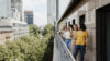 Vier Frauen stehen mit einem Kaltgetränk auf dem Balkon am Frankfurter Standort