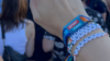 Hand with festival bracelet is stretched in the direction of the stage